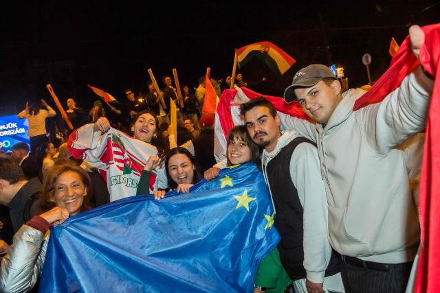 People celebrate in the streets after Hungarian Prime Minister Viktor Orban conceded defeat to Peter Magyar, leader of the pro-European conservative TISZA party, in Budapest, on April 12, 2026. Polls closed in Hungary's parliamentary election, with turnout reaching a record high in the crunch vote that sees nationalist Prime Minister Viktor Orban's 16-year stint in power face an unprecedented challenge from conservative political newcomer Peter Magyar. (Photo by Ferenc ISZA / AFP)