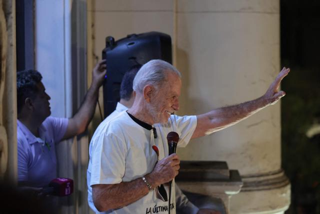 Peru’s presidential candidate Ricardo Belmont, running for the Civico Obras party, waves to his supporters at his party headquarters in Lima on April 12, 2026. Police and prosecutors raided Peru’s electoral authority on April 12, as the country faced a deepening political crisis, after more than 63,000 voters were unable to cast their ballots in the presidential election due to the failure to deliver ballots, ballot boxes and other essential materials. (Photo by Connie FRANCE / AFP)