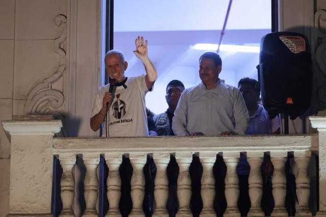 Peru’s presidential candidate Ricardo Belmont, running for the Civico Obras party, waves to his supporters from a balcony at his party headquarters in Lima on April 12, 2026. Police and prosecutors raided Peru’s electoral authority on April 12, as the country faced a deepening political crisis, after more than 63,000 voters were unable to cast their ballots in the presidential election due to the failure to deliver ballots, ballot boxes and other essential materials. (Photo by Connie FRANCE / AFP)
