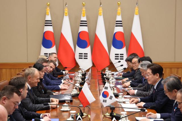 South Korean President Lee Jae Myung (3rd R) attends a meeting with Polish Prime Minister Donald Tusk (3rd L) at the Blue House in Seoul on April 13, 2026.  (Photo by Chung Sung-Jun / POOL / AFP)