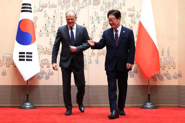 South Korean President Lee Jae Myung (R) gestures to Polish Prime Minister Donald Tusk during their meeting at the Blue House in Seoul on April 13, 2026.  (Photo by Chung Sung-Jun / POOL / AFP)