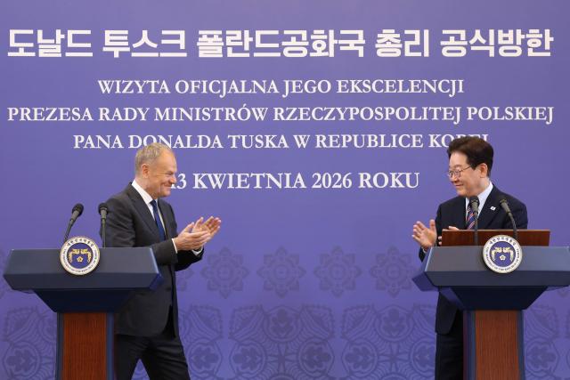 South Korean President Lee Jae Myung (R) and Poland's Prime Minister Donald Tusk attend a joint press conference at the presidential Blue House in Seoul on April 13, 2026.  (Photo by Chung Sung-Jun / POOL / AFP)