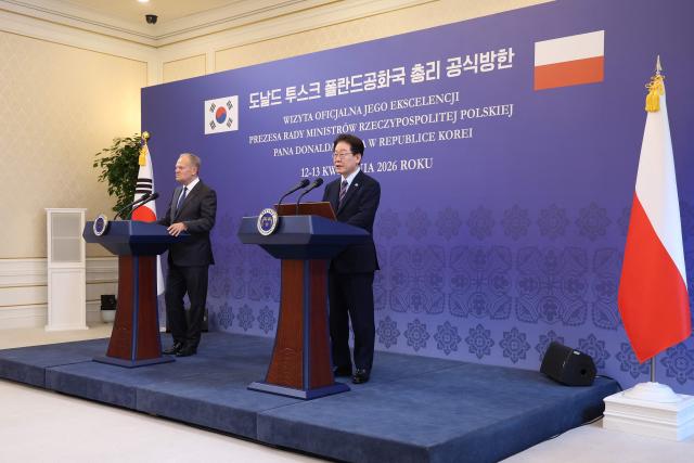 South Korean President Lee Jae Myung (R) and Poland's Prime Minister Donald Tusk attend a joint press conference at the presidential Blue House in Seoul on April 13, 2026.  (Photo by Chung Sung-Jun / POOL / AFP)