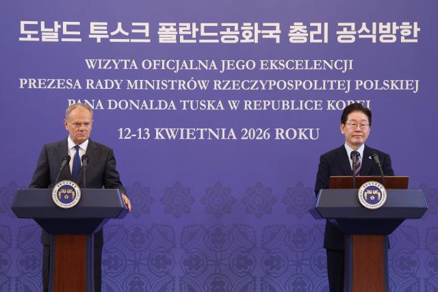 South Korean President Lee Jae Myung (R) and Poland's Prime Minister Donald Tusk attend a joint press conference at the presidential Blue House in Seoul on April 13, 2026.  (Photo by Chung Sung-Jun / POOL / AFP)