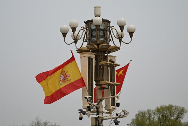 The national flags of Spain and China hang near Tiananmen Gate during a visit by Spain's Prime Minister Pedro Sanchez in Beijing on April 13, 2026. (Photo by Pedro PARDO / AFP)