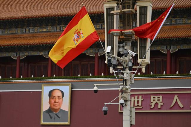 The national flags of Spain and China hang in front of the portrait of late communist leader Mao Zedong at Tiananmen Gate during a visit by Spain's Prime Minister Pedro Sanchez in Beijing on April 13, 2026. (Photo by Pedro PARDO / AFP)