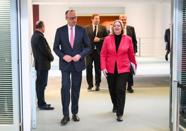 German Chancellor Friedrich Merz and German Minister for Labour and Social Affairs Baerbel Bas (SPD) followed by German Finance Minister and Vice Chancellor Lars Klingbeil (SPD, back C) and Bavaria's State Premier and leader of the conservative Christian Social Union (CSU) Markus Soeder (R) arrive for a press briefing on the results of their overnight coalition committee consultations, on April 13, 2026 at the Chancellery in Berlin. Chancellor Friedrich Merz said that Germany would cut petrol and diesel taxes for two months to provide relief to households and businesses hit by the energy shock during the Middle East war. (Photo by RALF HIRSCHBERGER / AFP)