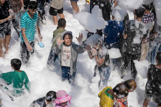 People play with soap suds during celebrations for Myanmar's Buddhist New Year water festival, also known as Thingyan, in Yangon on April 13, 2026. (Photo by Sai Aung MAIN / AFP)