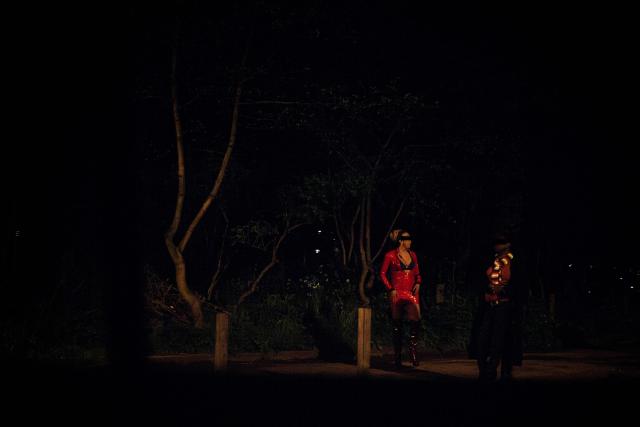 (FILES) Sex workers wait for clients standing in a street in the Bois de Boulogne, west of Paris, on March 30, 2024. A 2016 law in France criminalised the purchase of sexual services, reclassifying sex workers as victims and making clients liable to a fine of 1,500 euros. Ten years after the law, the organisations Federation Parapluie rouge, Amnesty International, Acceptess-T and the NousToutes collective are calling in a private member’s bill (PPL) to decriminalise sex work. (Photo by JULIEN DE ROSA / AFP)