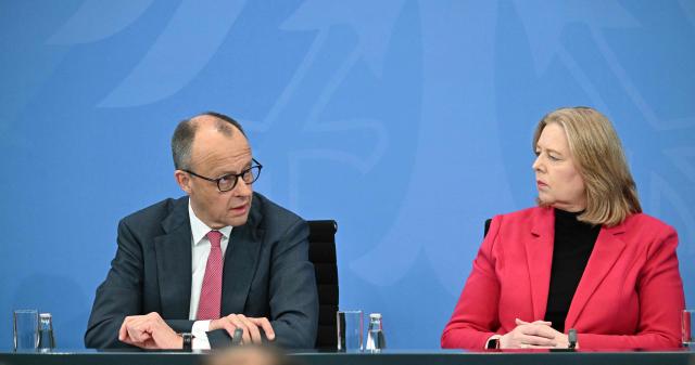 German Chancellor Friedrich Merz of the conservative Christian Democratic Union (CDU) party and German Minister for Labour and Social Affairs Baerbel Bas from the social democratic SPD party attend a press briefing on the results of overnight coalition committee consultations, on April 13, 2026 at the Chancellery in Berlin. Chancellor Friedrich Merz said that Germany would cut petrol and diesel taxes for two months to provide relief to households and businesses hit by the energy shock during the Middle East war. (Photo by RALF HIRSCHBERGER / AFP)