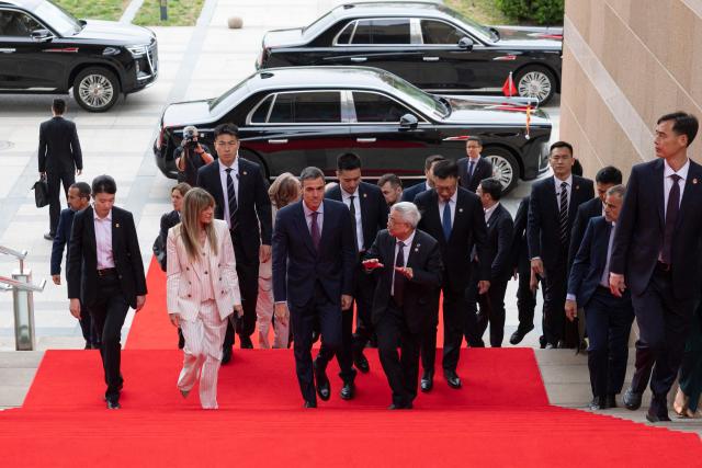 Spain's Prime Minister Pedro Sanchez (centre, L) and his wife Begona Gomez arrive to the University of Chinese Academy of Sciences in Beijing on April 13, 2026. Sanchez called China's trade imbalance with the European Union "unsustainable" on April 13, as he began a three-day visit to Beijing where he hopes to strengthen economic ties. (Photo by ANDRES MARTINEZ CASARES / POOL / AFP)