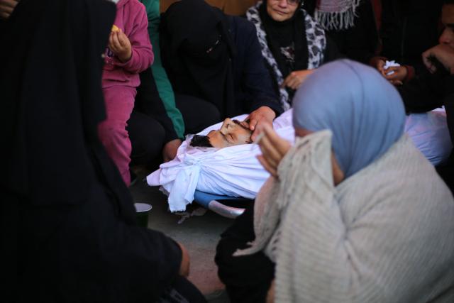 Mourners react during the funeral of Palestinians who, according to a medic, were killed the night before in an Israeli strike at al-Aqsa Martyrs Hospital in Deir al Balah, central Gaza Strip, on April 13, 2026. Both Israel and Hamas have accused each other of breaching the US-backed truce, which has largely halted the two-year war that devastated the enclave of 2.2 million. A delegation from Hamas was set to hold talks with Egyptian mediators in Cairo on April 12, 2026, to address alleged Israeli violations of the Gaza ceasefire, according to two officials from the Palestinian group. (Photo by Eyad Baba / AFP)