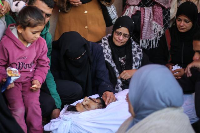 Female mourners gather around the body during the funeral of a Palestinian man who, according to a medic, was killed the previous night in an Israeli strike at al-Aqsa Martyrs Hospital in Deir al Balah in the central Gaza Strip on April 13, 2026. Both Israel and Hamas have accused each other of breaching the US-backed truce, which has largely halted the two-year war that devastated the enclave of 2.2 million. A delegation from Hamas was set to hold talks with Egyptian mediators in Cairo on April 12, 2026, to address alleged Israeli violations of the Gaza ceasefire, according to two officials from the Palestinian group. (Photo by Eyad Baba / AFP)