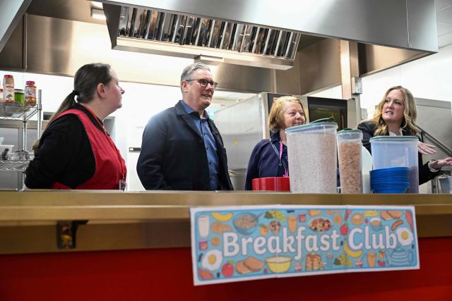 Britain's Prime Minister Keir Starmer (2nd L) meets with staff at a breakfast club during his visit to a primary school in Ashton-under-Lyne, Greater Manchester, north-west England on April 13, 2026. (Photo by Paul ELLIS / POOL / AFP)
