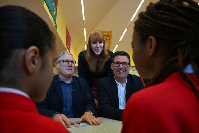 Britain's Prime Minister Keir Starmer (L), Labour Party MP and former deputy prime minister, Angela Rayner (C) and Manchester Mayor Andy Burnham (R) meet with schoolchildren during a visit to a primary school in Ashton-under-Lyne, Greater Manchester, north-west England on April 13, 2026. (Photo by Paul ELLIS / POOL / AFP)