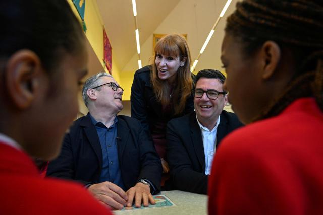 Britain's Prime Minister Keir Starmer (L), Labour Party MP and former deputy prime minister, Angela Rayner (C) and Manchester Mayor Andy Burnham (R) meet with schoolchildren during a visit to a primary school in Ashton-under-Lyne, Greater Manchester, north-west England on April 13, 2026. (Photo by Paul ELLIS / POOL / AFP)