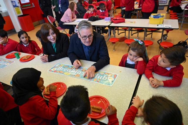 Britain's Prime Minister Keir Starmer (C) and Britain's Education Secretary Bridget Phillipson (2nd L) meet school children at a breakfast club during a visit to a primary school in Ashton-under-Lyne, Greater Manchester, north-west England on April 13, 2026. (Photo by Paul ELLIS / POOL / AFP)