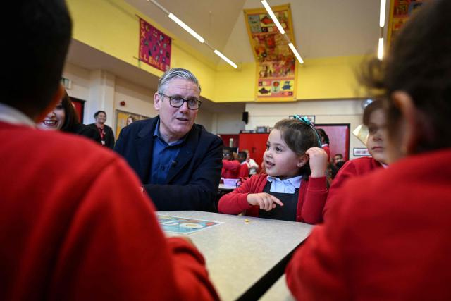 Britain's Prime Minister Keir Starmer (L) meets school children at a breakfast club with Manchester Mayor Andy Burnham, during a visit to a primary school in Ashton-under-Lyne, Greater Manchester, north-west England on April 13, 2026. (Photo by Paul ELLIS / POOL / AFP)