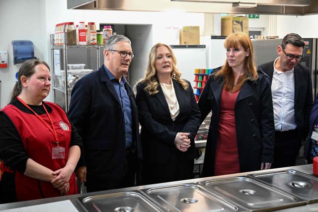 Britain's Prime Minister Keir Starmer (2nd L), Labour Party MP and former deputy prime minister, Angela Rayner (2nd R) and Manchester Mayor Andy Burnham (R) meet with staff at a breakfast club during a visit to a primary school in Ashton-under-Lyne, Greater Manchester, north-west England on April 13, 2026. (Photo by Paul ELLIS / POOL / AFP)