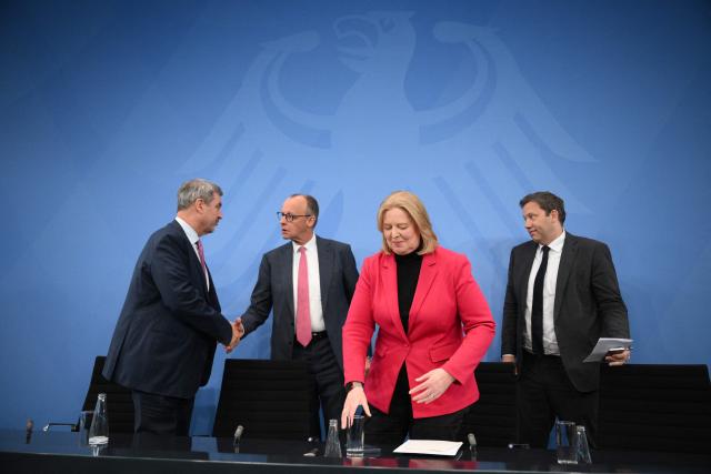 (L-R) Bavaria's State Premier and leader of the conservative Christian Social Union (CSU) Markus Soeder, German Chancellor Friedrich Merz of the conservative Christian Democratic Union (CDU), German Minister for Labour and Social Affairs Baerbel Bas from the social democratic SPD party, and German Finance Minister and Vice Chancellor Lars Klingbeil (SPD) leave after a press briefing on the results of overnight coalition committee consultations, on April 13, 2026 at the Chancellery in Berlin. Chancellor Friedrich Merz said that Germany would cut petrol and diesel taxes for two months to provide relief to households and businesses hit by the energy shock during the Middle East war. (Photo by RALF HIRSCHBERGER / AFP)