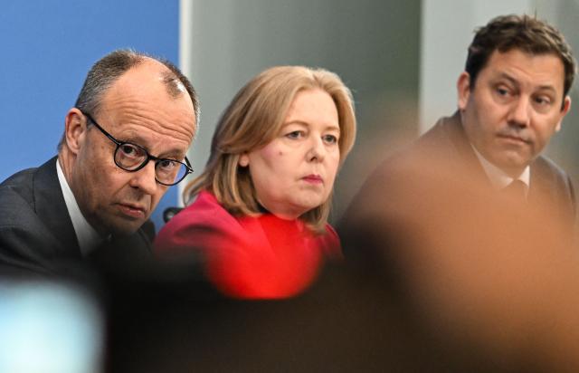 (L-R) German Chancellor Friedrich Merz, German Minister for Labour and Social Affairs Baerbel Bas (SPD) and German Finance Minister and Vice Chancellor Lars Klingbeil (SPD) attend a press briefing on the results of their overnight coalition committee consultations, on April 13, 2026 at the Chancellery in Berlin. Chancellor Friedrich Merz said that Germany would cut petrol and diesel taxes for two months to provide relief to households and businesses hit by the energy shock during the Middle East war. (Photo by RALF HIRSCHBERGER / AFP)