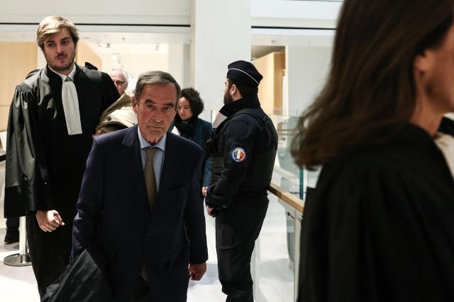 Former CEO of Lafarge Bruno Lafont (C) arrives on the day of the verdict in the trial of the French cement group Lafarge accused of financing terrorism in Syria, at the Paris courthouse, in Paris on April 13, 2026. The Paris criminal court will deliver its verdict against the cement company and eight former executives of the group, accused of financing terrorism for having paid jihadist groups to keep a factory running in the middle of the war in Syria. (Photo by Behrouz MEHRI / AFP)