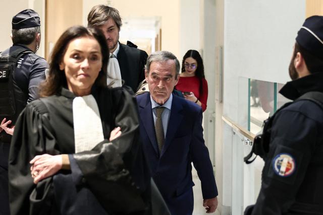 Former CEO of Lafarge Bruno Lafont (C) arrives on the day of the verdict in the trial of the French cement group Lafarge accused of financing terrorism in Syria, at the Paris courthouse, in Paris on April 13, 2026. The Paris criminal court will deliver its verdict against the cement company and eight former executives of the group, accused of financing terrorism for having paid jihadist groups to keep a factory running in the middle of the war in Syria. (Photo by Behrouz MEHRI / AFP)