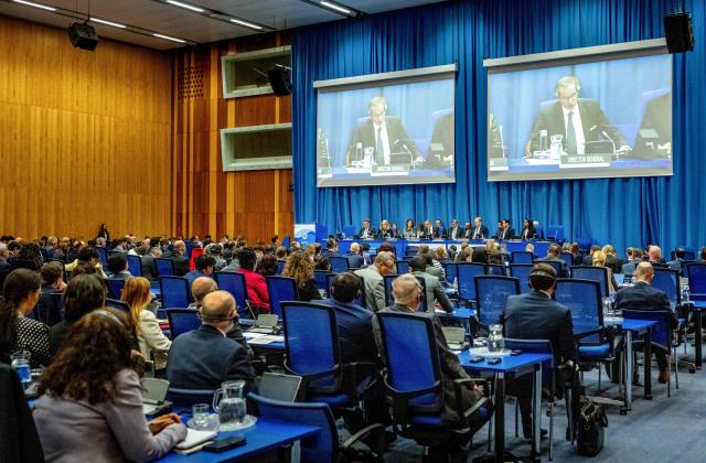 The Director General of the International Atomic Energy Agency (IAEA) Rafael Grossi appears on screens as he addresses the opening plenary session of IAEA’s Tenth Review Meeting at the agency's headquarters in Vienna, Austria, on April 13, 2026. (Photo by Joe Klamar / AFP)