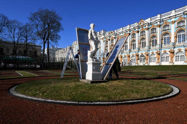 Museum workers remove winter protective cases off authentic Venetian marble statues at the Catherine Park in the Tsarskoye Selo Museum-Reserve in Pushkin outside Saint Petersburg on April 13, 2026. (Photo by Olga MALTSEVA / AFP)
