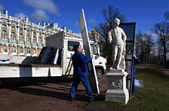 Museum workers remove winter protective cases off authentic Venetian marble statues at the Catherine Park in the Tsarskoye Selo Museum-Reserve in Pushkin outside Saint Petersburg on April 13, 2026. (Photo by Olga MALTSEVA / AFP)