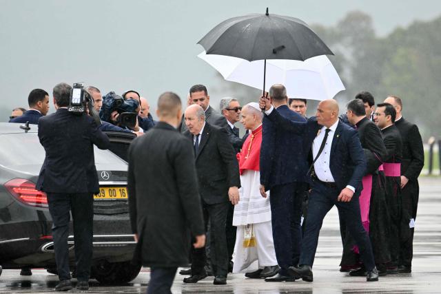Pope Leo XIV is welcomed by Algeria's President Abdelmadjid Tebboune after landing at the Houari Boumediene International Airport on April 13, 2026. Pope Leo XIV embarks today on an 11-day visit to Algeria, Cameroon, Angola and Equatorial Guinea for his first major international trip since becoming pontiff last year. (Photo by Alberto PIZZOLI / AFP)