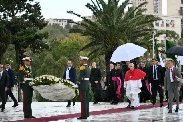 Pope Leo XIV lays a wreath of flowers as he visits the Maqam Echahid Martyrs’ Monument in El Madania, near Algiers on April 13, 2026. Pope Leo XIV embarks today on an 11-day visit to Algeria, Cameroon, Angola and Equatorial Guinea for his first major international trip since becoming pontiff last year. (Photo by Alberto PIZZOLI / POOL / AFP)