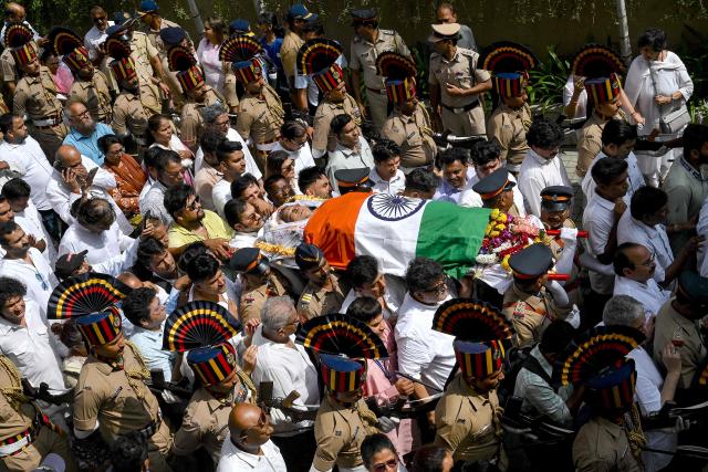 Mouners carry the body of late Bollywood playback singer Asha Bhosle, shrouded in India national flag during her funeral procession in Mumbai on April 13, 2026. Legendary Indian playback singer Bhosle, whose voice defined Bollywood music through the 1970s and 80s, died on April 12 in Mumbai aged 92, her family said. (Photo by Sujit JAISWAL / AFP)