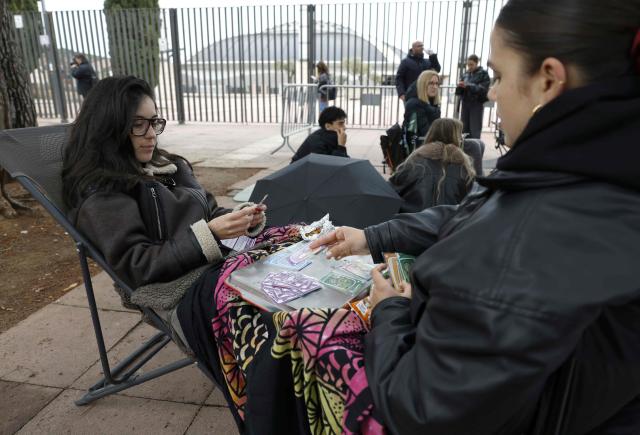 Fans of Spanish singer and songwriter Rosalia play cards while waiting prior her concert in Barcelona on April 13, 2026. (Photo by Lluis GENE / AFP)