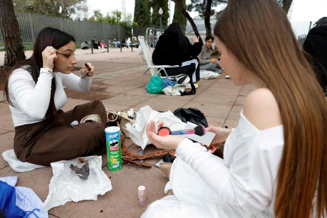 Fans of Spanish singer and songwriter Rosalia put on make up while waiting prior her concert in Barcelona on April 13, 2026. (Photo by Lluis GENE / AFP)