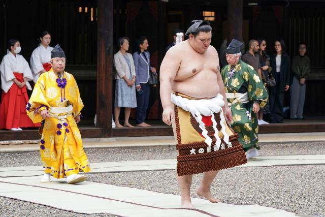 Onosato (R), who holds the highest rank of Yokozuna (grand champion) in sumo wrestling, takes part in a traditional Shinto ceremony at Yasukuni Shrine in Tokyo on April 13, 2026, during the annual "honozumo", a ceremonial one-day exhibition for spectators held within the shrine's precincts. (Photo by Kazuhiro NOGI / AFP)