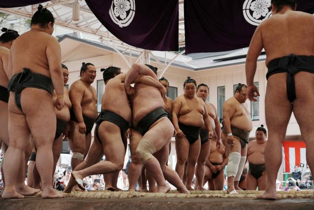 Lower-ranked sumo wrestlers practice before the annual "honozumo", a ceremonial one-day sumo exhibition for spectators held at Yasukuni Shrine in Tokyo on April 13, 2026. (Photo by Kazuhiro NOGI / AFP)