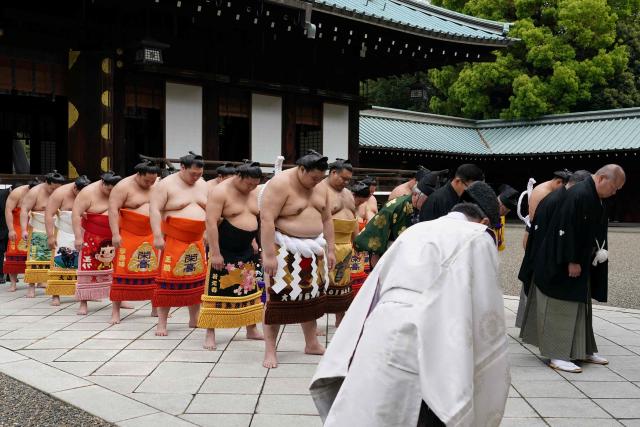 Top ranking sumo wrestlers bow as they take part in a traditional Shinto ceremony at Yasukuni Shrine in Tokyo on April 13, 2026, during the annual "honozumo", a ceremonial one-day exhibition for spectators held within the shrine's precincts. (Photo by Kazuhiro NOGI / AFP)