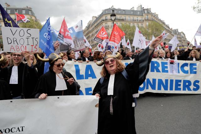 Lawyers hold a banner as they take part in a demonstration against the Darmanin law, which intends to shorten trial times, in Paris on April 13, 2026. The criminal justice reform promoted by France's Justice Minister arrives on April 13 in the Senate chamber, accompanied by a mobilization of lawyers criticizing a reform that will be "to the detriment of the rights of the defense and of victims". (Photo by Ludovic MARIN / AFP)