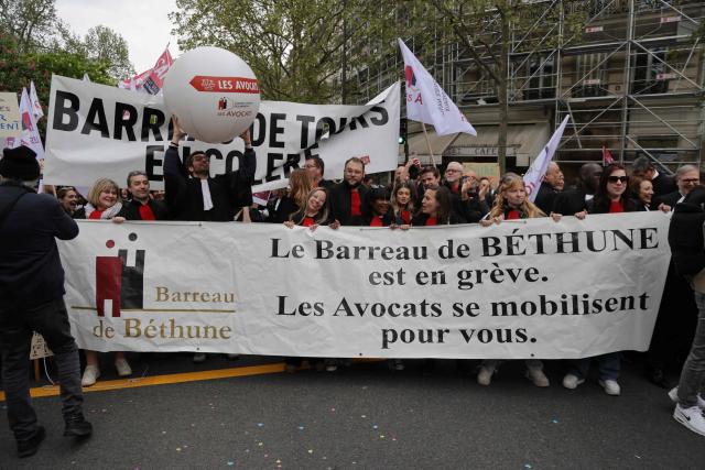 Lawyers hold a banner reading "The Bethune Bar Association is on strike. Lawyers are rallying to support you" as they take part in a demonstration against the Darmanin law, which intends to shorten trial times, in Paris on April 13, 2026. The criminal justice reform promoted by France's Justice Minister arrives on April 13 in the Senate chamber, accompanied by a mobilization of lawyers criticizing a reform that will be "to the detriment of the rights of the defense and of victims". (Photo by Ludovic MARIN / AFP)