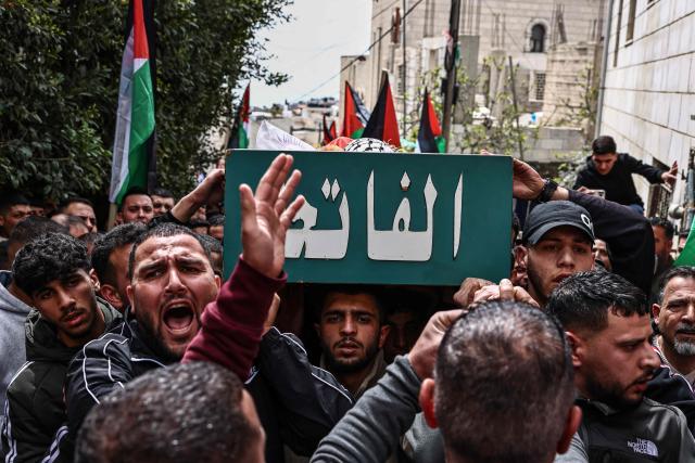 EDITORS NOTE: Graphic content / Mourners of 23-year-old Ali Majed Hamadneh carry his coffin during his funeral in the village of Deir Jarir, northeast of the city of Ramallah in the Israeli-occupied Palestinian West Bank on April 13, 2026. The Palestinian health ministry reported on April 12, 2026, that Israeli settlers shot dead Hamadneh in the occupied West Bank, while the military said a soldier had opened fire during a "violent riot". Violence in the West Bank, which Israel has occupied since 1967, has risen sharply since the October 7, 2023 Hamas attack on Israel triggered the Gaza war. (Photo by Zain JAAFAR / AFP)