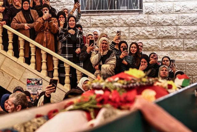 EDITORS NOTE: Graphic content / TOPSHOT - Relatives of 23-year-old Ali Majed Hamadneh gather during his funeral in the village of Deir Jarir, northeast of the city of Ramallah, in the Israeli-occupied Palestinian West Bank on April 13, 2026. The Palestinian health ministry reported on April 12, 2026, that Israeli settlers shot dead Hamadneh in the occupied West Bank, while the military said a soldier had opened fire during a "violent riot". Violence in the West Bank, which Israel has occupied since 1967, has risen sharply since the October 7, 2023 Hamas attack on Israel triggered the Gaza war. (Photo by Zain JAAFAR / AFP)