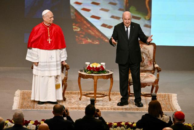 Pope Leo XIV and Algeria's President Abdelmadjid Tebboune attend a meeting with the civil society and the diplomatic corps at the “Djamaa el Djazair” Conference Center on April 13, 2026. Pope Leo XIV embarks today on an 11-day visit to Algeria, Cameroon, Angola and Equatorial Guinea for his first major international trip since becoming pontiff last year. (Photo by Alberto PIZZOLI / AFP)