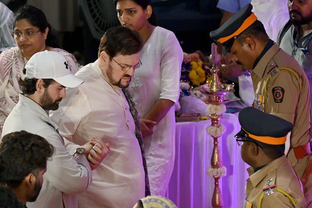 Bollywood actor Neil Nitin Mukesh (3L) with his father and playback singer Nitin Mukesh (C) arrives to pays his respects during the state funeral ceremony of playback singer Asha Bhosle in Mumbai on April 13, 2026. Legendary Indian playback singer Bhosle, whose voice defined Bollywood music through the 1970s and 80s, died on April 12 in Mumbai aged 92, her family said. (Photo by Sujit JAISWAL / AFP)