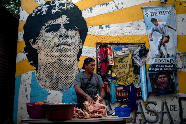 Alejandro, a volunteer, prepares meat for a stew for neighbours in need at the yard of the childhood home of the late football star Diego Maradona, now transformed into a soup kitchen, in Villa Fiorito, Buenos Aires province, Argentina, on April 9, 2026. The second trial over the death of football star Diego Maradona begins on April 14, 2026, after the first one, which took place last year, was annulled when it was discovered that one of the judges was taking part in a clandestine documentary about the proceedings. (Photo by TOMAS CUESTA / AFP)