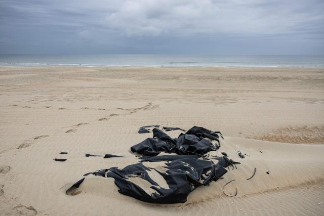 This photograph shows the remains of a damaged smuggling boat on the beach of Gravelines, northern France, on April, 13, 2026. (Photo by Sameer Al-DOUMY / AFP)