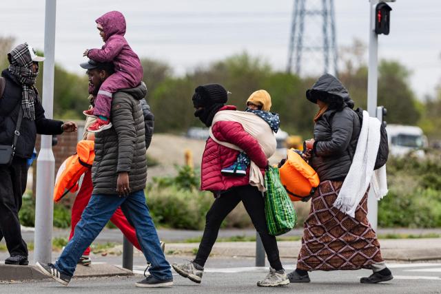 Migrants head to a beach to be smuggled to Britain through the English Channel, in Grande-Synthe, near Dunkirk, northern France on April, 13, 2026. (Photo by Sameer Al-DOUMY / AFP)