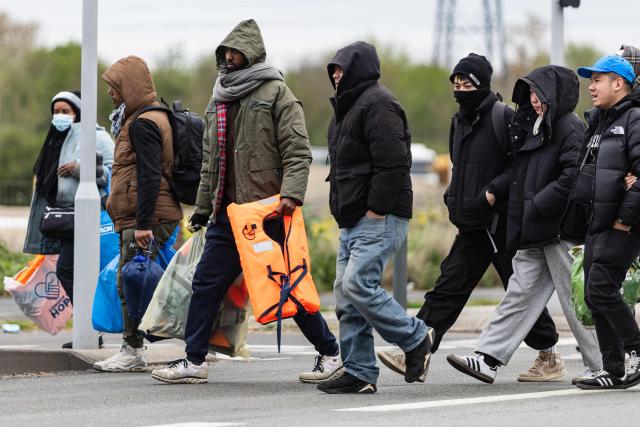 Migrants head to a beach to be smuggled to Britain through the English Channel, in Grande-Synthe, near Dunkirk, northern France on April, 13, 2026. (Photo by Sameer Al-DOUMY / AFP)