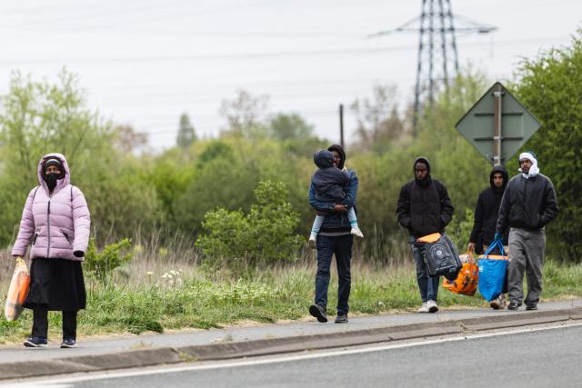 Migrants head to a beach to be smuggled to Britain through the English Channel, in Grande-Synthe, near Dunkirk, northern France on April, 13, 2026. (Photo by Sameer Al-DOUMY / AFP)