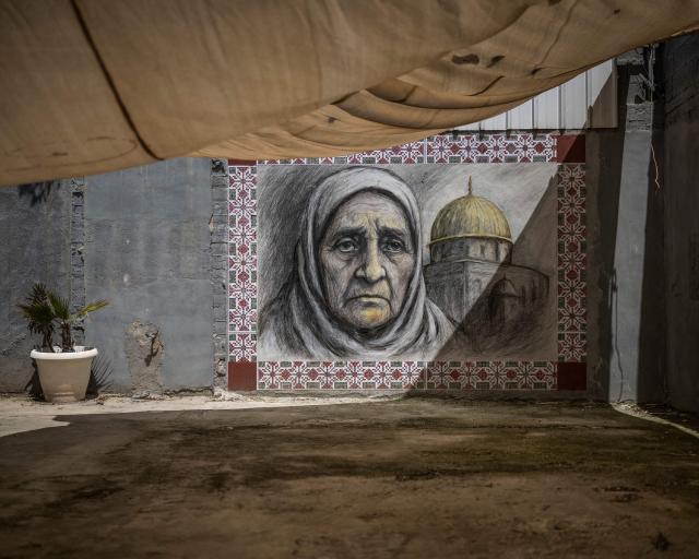 A photograph shows a graffiti depicting the Dome of the Rock and the mother of Fakhri Abu Diab, longtime activist and resident of al-Bustan neighbourhood, at the entrance of the demolished family home, in Silwan in Israeli-annexed east Jerusalem, on April 12, 2026. Left with only a trailer on his family land, Diab received yet another injunction from the Jerusalem Municipality to tear down the temporary structure.
Israeli authorities regularly target what they describe as unauthorised construction in Jerusalem's annexed east, a campaign that local Palestinian officials characterise as a "systematic policy" to displace residents. (Photo by MARCO LONGARI / AFP)